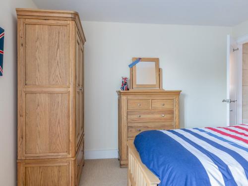 a bedroom with a dresser and a bed with a mirror at Welsummer in Salcombe