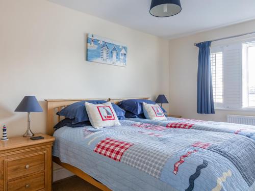 a bedroom with a bed with a blue and red blanket at Welsummer in Salcombe