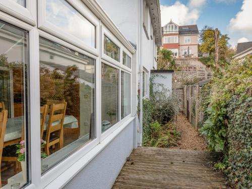 a porch of a house with windows and a wooden walkway at Welsummer in Salcombe