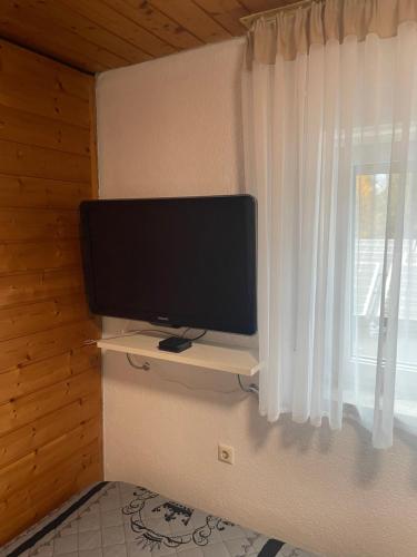 uma televisão de ecrã plano sentada numa parede ao lado de uma janela em Euro S Markt em Biberach an der Riss