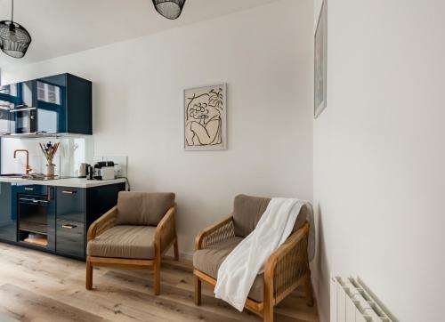 Il comprend un salon avec deux chaises et une cuisine. dans l'établissement La Petite Cordonnerie, à Honfleur