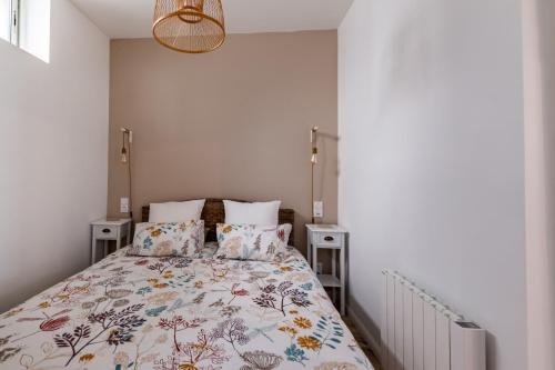 une chambre avec un lit avec un couvre-lit fleuri dans l'établissement La Petite Cordonnerie, à Honfleur