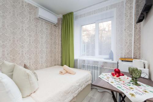 a small room with a bed and a table with fruit on it at Отличная студия в центре in Almaty