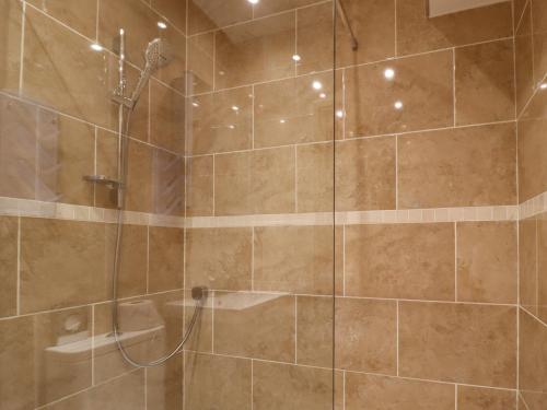 a bathroom with a shower with a glass door at Ash Cottage in Skipton
