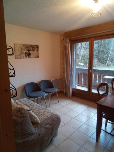 un salon avec un canapé et une fenêtre dans l'établissement cimes d'or, aux Contamines-Montjoie