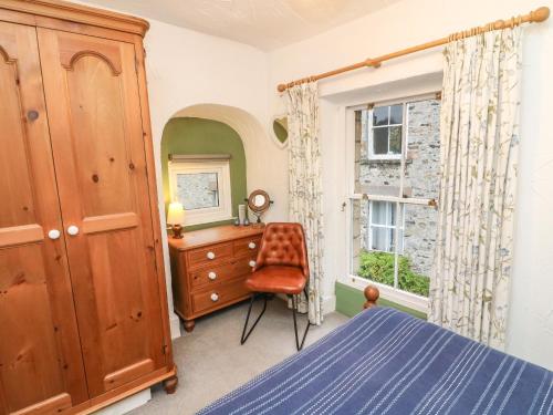 a bedroom with a bed and a dresser and a window at Pauls Fold Holiday Cottage in Ingleton 