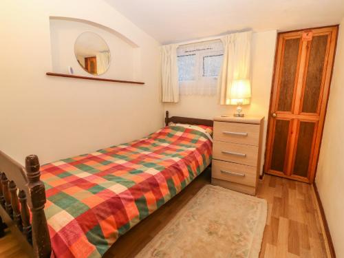 a bedroom with a bed and a dresser and a mirror at Brig Y Don in Caernarfon