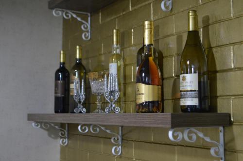 a shelf with wine bottles and glasses on a brick wall at Renaissance Hotel Tbilisi in Tbilisi City