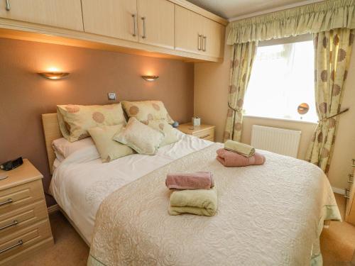 Un dormitorio con una cama con dos toallas encima. en Mallard Lodge, en Carnforth