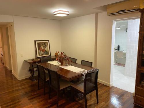 comedor con mesa de madera y sillas en Charmoso apartamento no melhor ponto de Ipanema, en Río de Janeiro