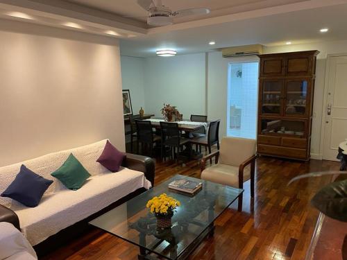 uma sala de estar com um sofá e uma mesa em Charmoso apartamento no melhor ponto de Ipanema no Rio de Janeiro