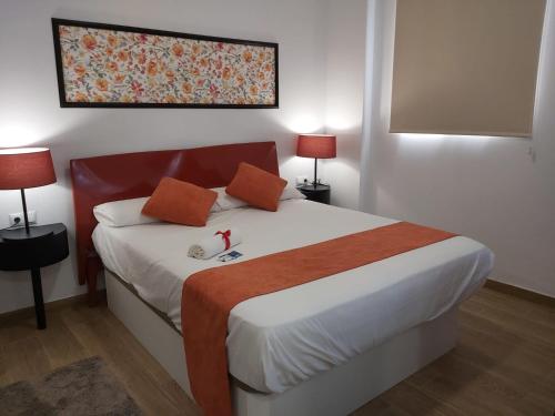 una camera da letto con un grande letto con due lampade sopra di Apartamentos Rous - Solo adultos a Valencia