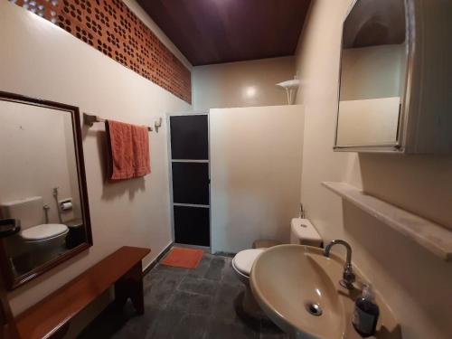 a bathroom with a sink and a toilet and a mirror at Solar do Sal in Salinópolis
