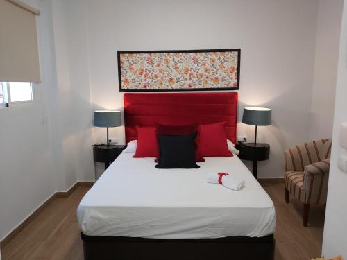 1 dormitorio con 1 cama grande y cabecero rojo en Apartamentos Rous - Solo adultos, en Valencia