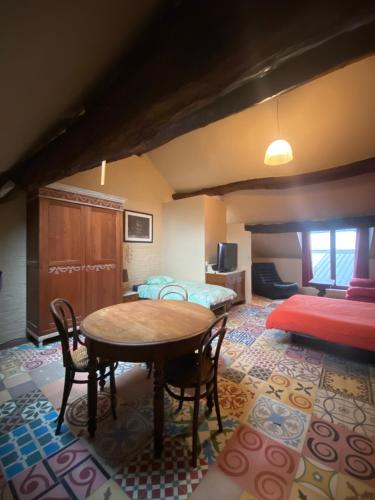 um quarto com uma mesa e cadeiras e uma cama em B&B Le Moulin de Fernelmont em Forville