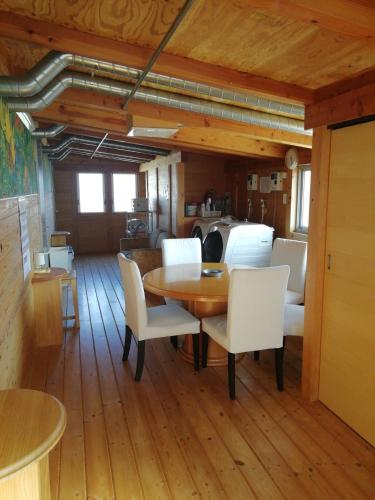 a dining room with a table and white chairs at Naoshima Accommodation Menjuku Ura - Vacation STAY 92589v in Naoshima