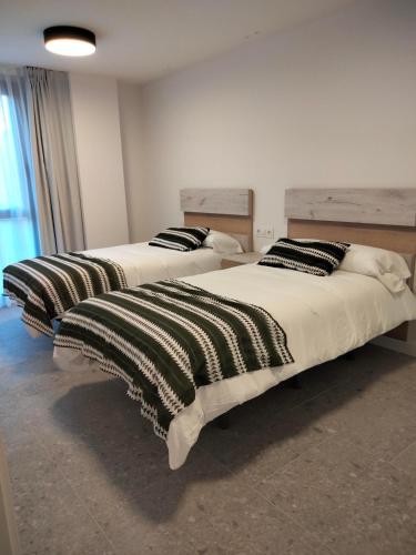 two beds sitting in a room withskirts at Apartamentos Hispano Nájera in Nájera