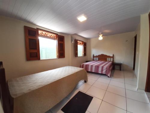 a hotel room with two beds and a window at Solar do Sal in Salinópolis
