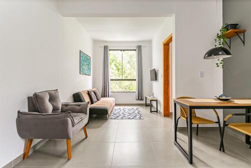 un salon avec un canapé et une table dans l'établissement Flats das Palmeiras, à Florianópolis