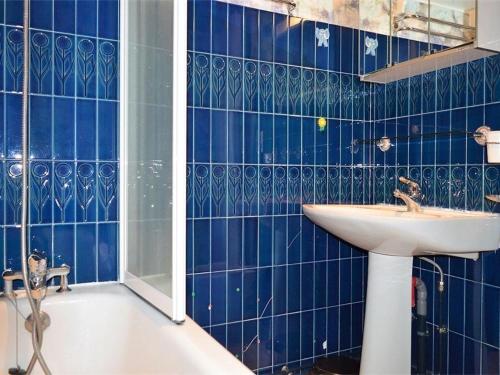 une salle de bain carrelée bleue avec un lavabo et une baignoire dans l'établissement Appartement 3P pour 6 pers avec parking et cuisine équipée, exposé plein sud, près du golf - FR-1-580-32, à Font-Romeu-Odeillo-Via