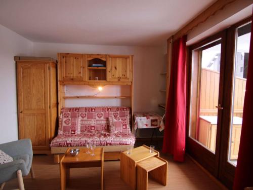 une petite chambre avec un lit avec une couverture rouge dans l'établissement Charmant 2 Pièces Cabine aux Saisies - Rez-de-Chaussée, Balcon, 6 Pers. - Commerces à Proximité - FR-1-594-68, à Hauteluce