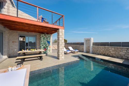 a villa with a swimming pool and a house at Southrock Villas in Lachania