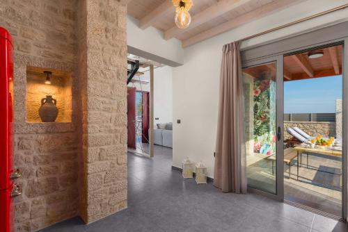 a living room with a red door and a balcony at Southrock Villas in Lachania