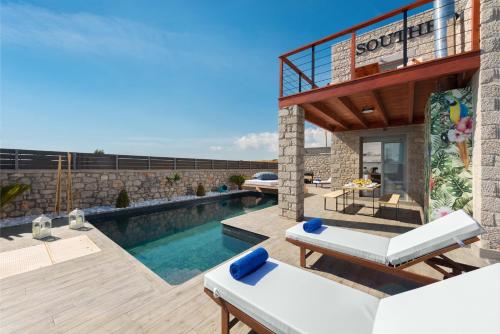 a villa with a swimming pool and a patio at Southrock Villas in Lachania