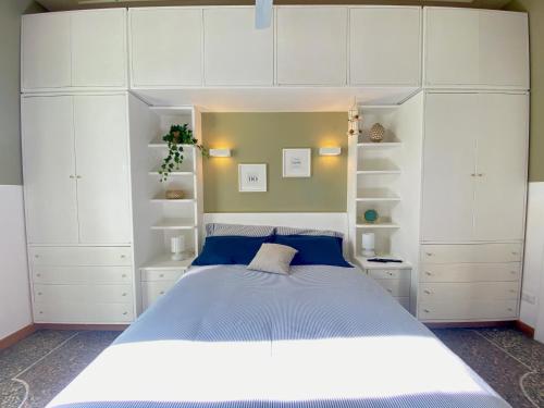 1 dormitorio con 1 cama grande y armarios blancos en La Casa di Miele - Center Rome apartment, en Roma