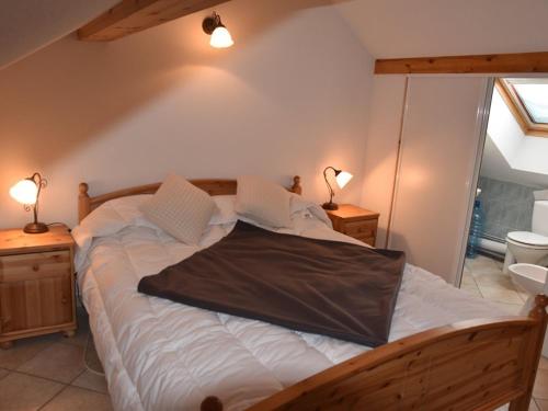 Cette chambre comprend un grand lit avec des draps blancs et 2 lampes. dans l'établissement Duplex 3 pièces 6 pers sous les toits avec balcon et garage - Montgenèvre - FR-1-266-163, à Montgenèvre