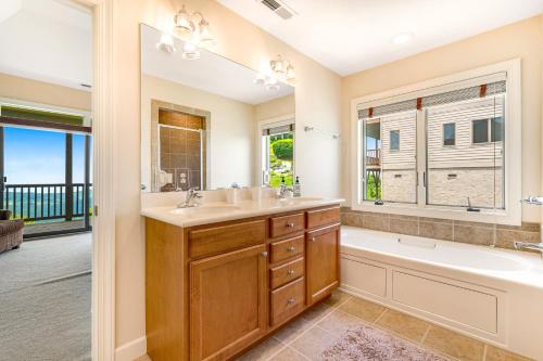 a bathroom with a tub and a sink and a tub and a toilet at Views for Miles at the Reserve in Sugar Mountain
