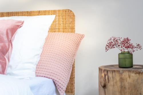 a bed with a pillow and a vase of flowers on a table at ROOM SAUVAGE in Vincennes