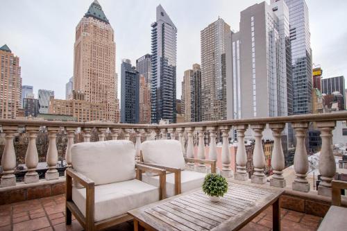 two chairs and a table on a balcony with a city skyline at Hotel Scherman in New York
