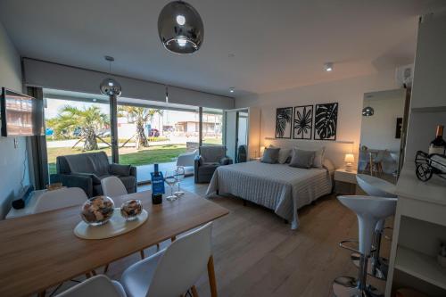 1 dormitorio y sala de estar con 1 cama y 1 mesa en SYRAH Premium B2 - Vistas al Parque by depptö, en Punta del Este