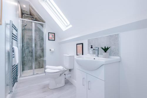 a white bathroom with a toilet and a sink at Parkview Place Serviced Apartment in Coventry