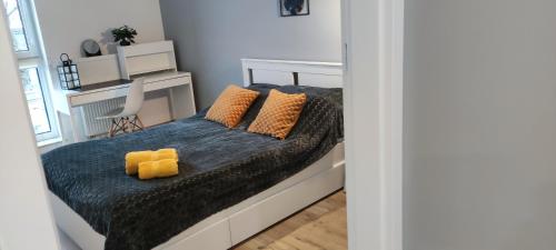 a bedroom with a bed with yellow pillows on it at Apartament przy Fabrycznym in Łódź