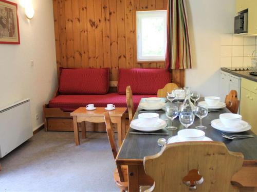 - une salle à manger avec une table et un canapé rouge dans l'établissement Appartement 3 pièces - 8 couchages - Proche pistes et commerces à Vars Les Claux - FR-1-330B-169, à Vars