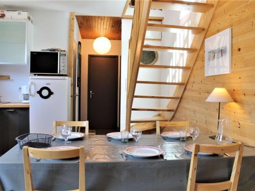 une salle à manger avec une table et des chaises et un escalier dans l'établissement Appartement mezzanine 6 couchages, pied de pistes, Risoul - FR-1-330-507, à Risoul
