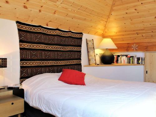 une chambre avec un lit avec un oreiller rouge dessus dans l'établissement Appartement mezzanine 6 couchages, pied de pistes, Risoul - FR-1-330-507, à Risoul