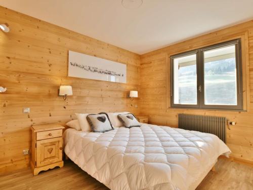 a bedroom with a large bed and a window at Appartement Le Grand-Bornand, 2 pièces, 6 personnes - FR-1-391-119 in Le Grand-Bornand