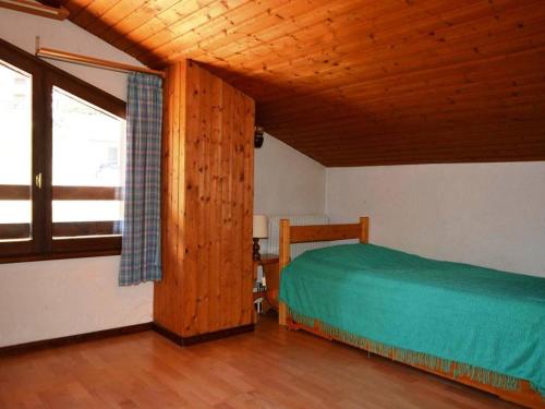a bedroom with a bed and a wooden ceiling at Appartement Le Grand-Bornand, 3 pièces, 6 personnes - FR-1-241-229 in Le Grand-Bornand