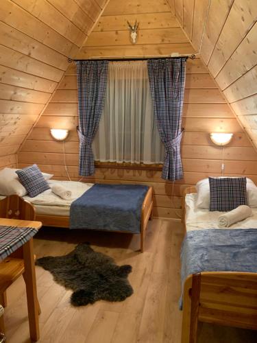ブコビナ・タトシャンスカにあるSkalnica Pokoje Gościnneの木造キャビン内のベッドルーム1室(ベッド2台付)