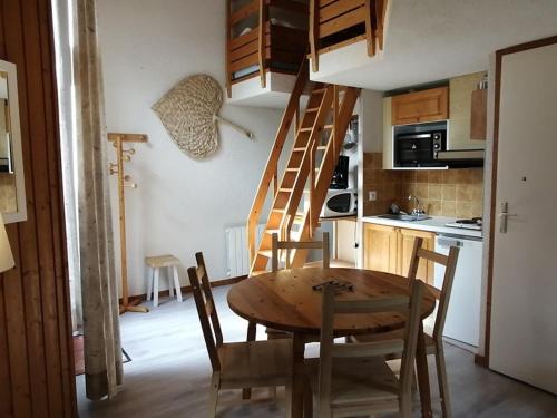 une cuisine avec une table en bois et un escalier en bois dans l'établissement Grand duplex 44m² 5 pers avec parking au centre de la station - FR-1-573-26, à Saint-Jean-dʼAulps