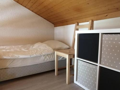 une petite chambre avec un lit et un bureau dans l'établissement Grand duplex 44m² 5 pers avec parking au centre de la station - FR-1-573-26, à Saint-Jean-dʼAulps
