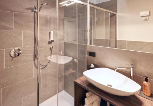 泰爾梅諾的住宿－Gartenheim Tramin，一间带水槽和玻璃淋浴的浴室