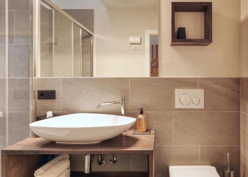 a bathroom with a white sink and a toilet at Gartenheim Tramin in Termeno