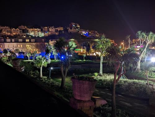 a view of a city at night with palm trees at Abingdon House in Torquay