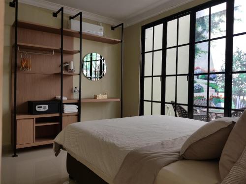 a bedroom with a large bed and large windows at Danka@tudor residence in Batam Center