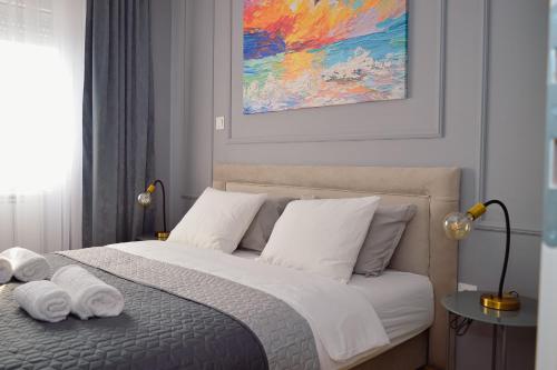 a bedroom with a bed with towels on it at CityInn Apartment in Bijeljina