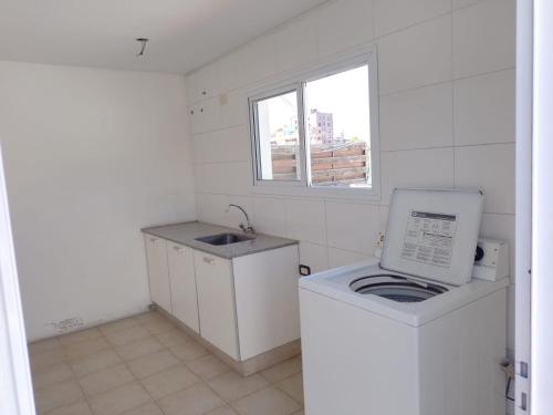 a small kitchen with a washing machine and a sink at Oasis 1.6 in Mendoza